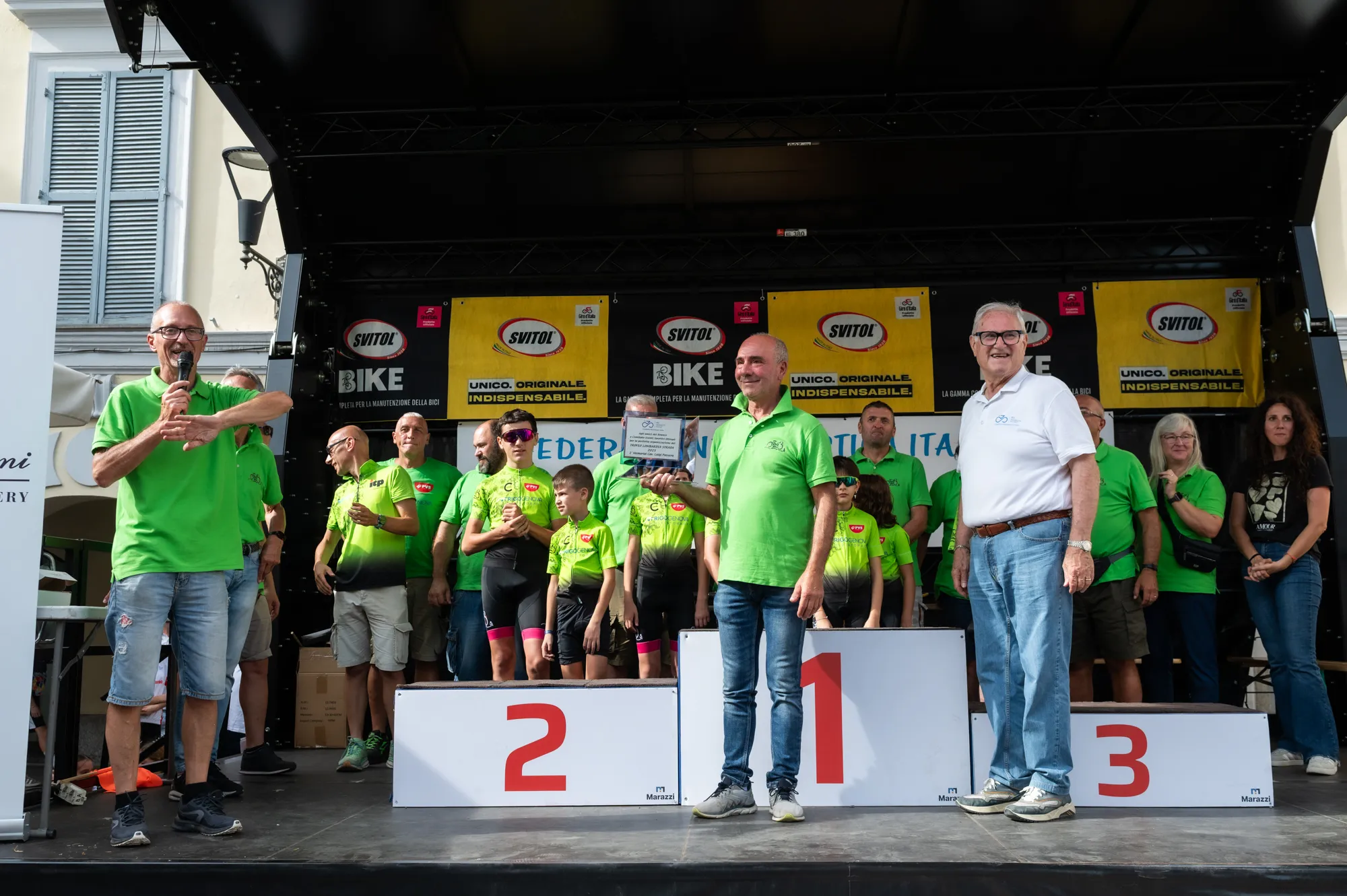 Giovani ciclisti e organizzatori riuniti sul palco di una premiazione